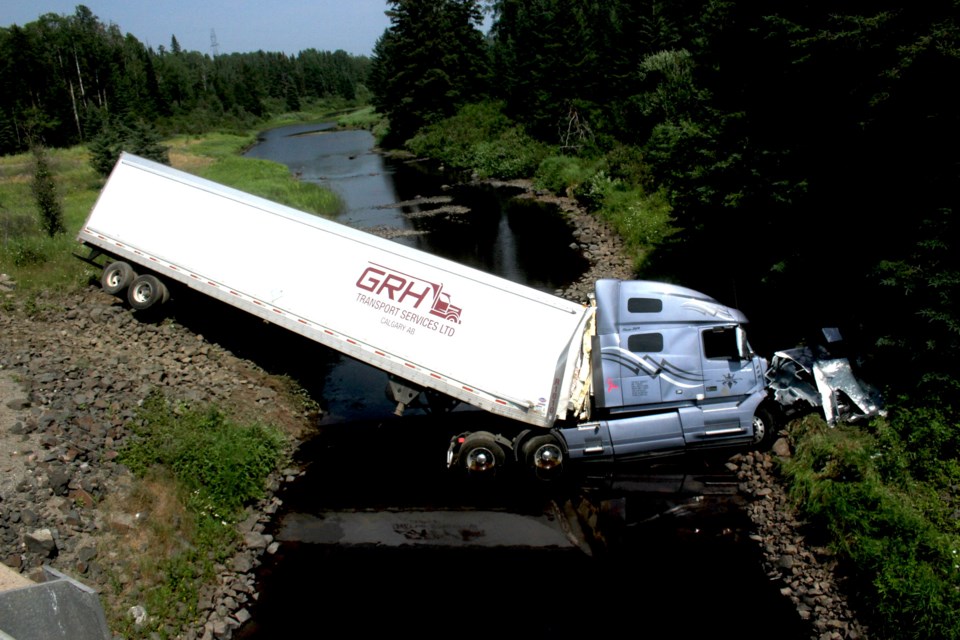 Jackknifed transport truck crashed over a creek in northern Ontario, illustrating the growing safety crisis linked to the Driver Inc Canada model.