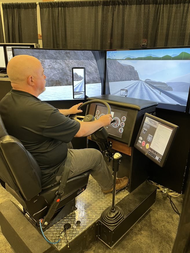 Commercial driver using a truck simulator to practice defensive driving techniques and hazard response training under Red Seal commercial driver standards in Canada.